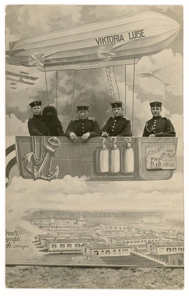 Soldiers with the mascot on a painted studio prop of the Viktoria Luise Zeppelin.
